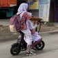 Ilustrasi: Anak sekolah mengendarai sepeda motor listrik