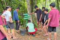 Pemasangan penunjuk jalan desa Sogian, oleh MahasiswaKKN UNIJA.
