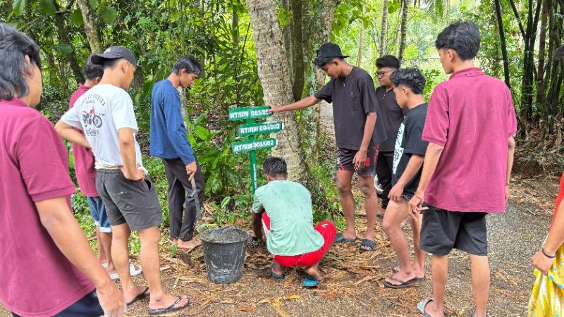 Pemasangan penunjuk jalan desa Sogian, oleh MahasiswaKKN UNIJA.